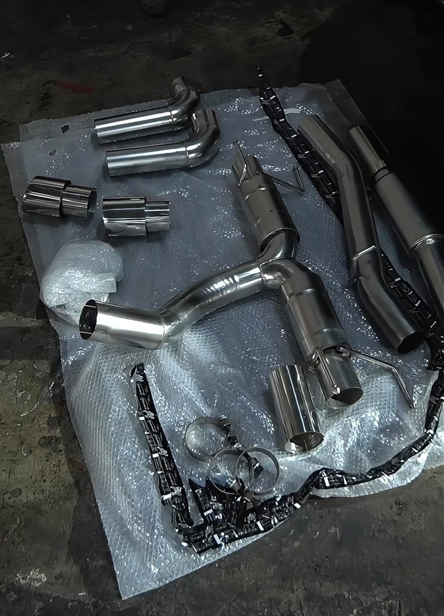 Polished exhaust pipes, tips and valves laid out on a protective sheet