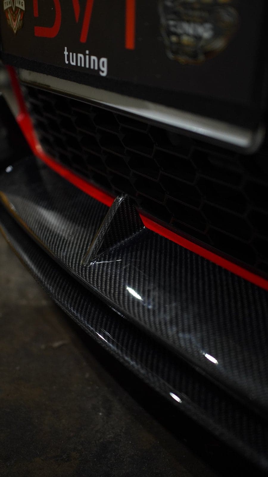 Glossy carbon fibre front lip and canard on a Toyota GR86 below a BVT Tuning plate