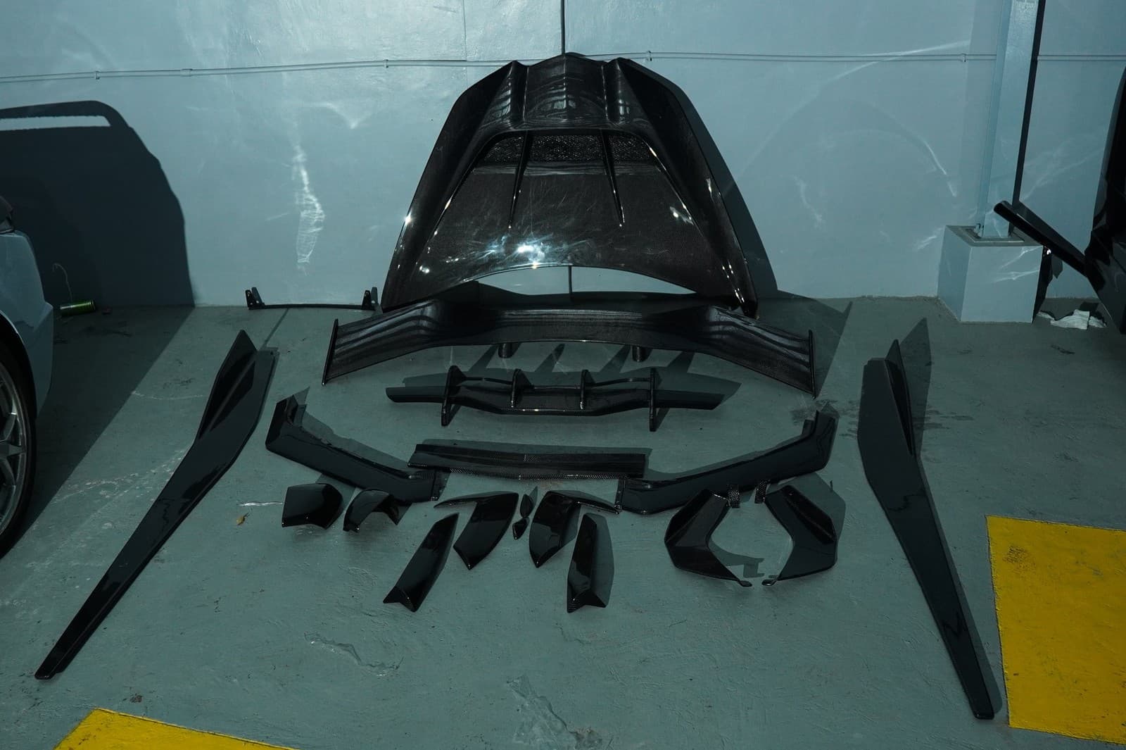 Carbon fiber body kit parts laid out before install