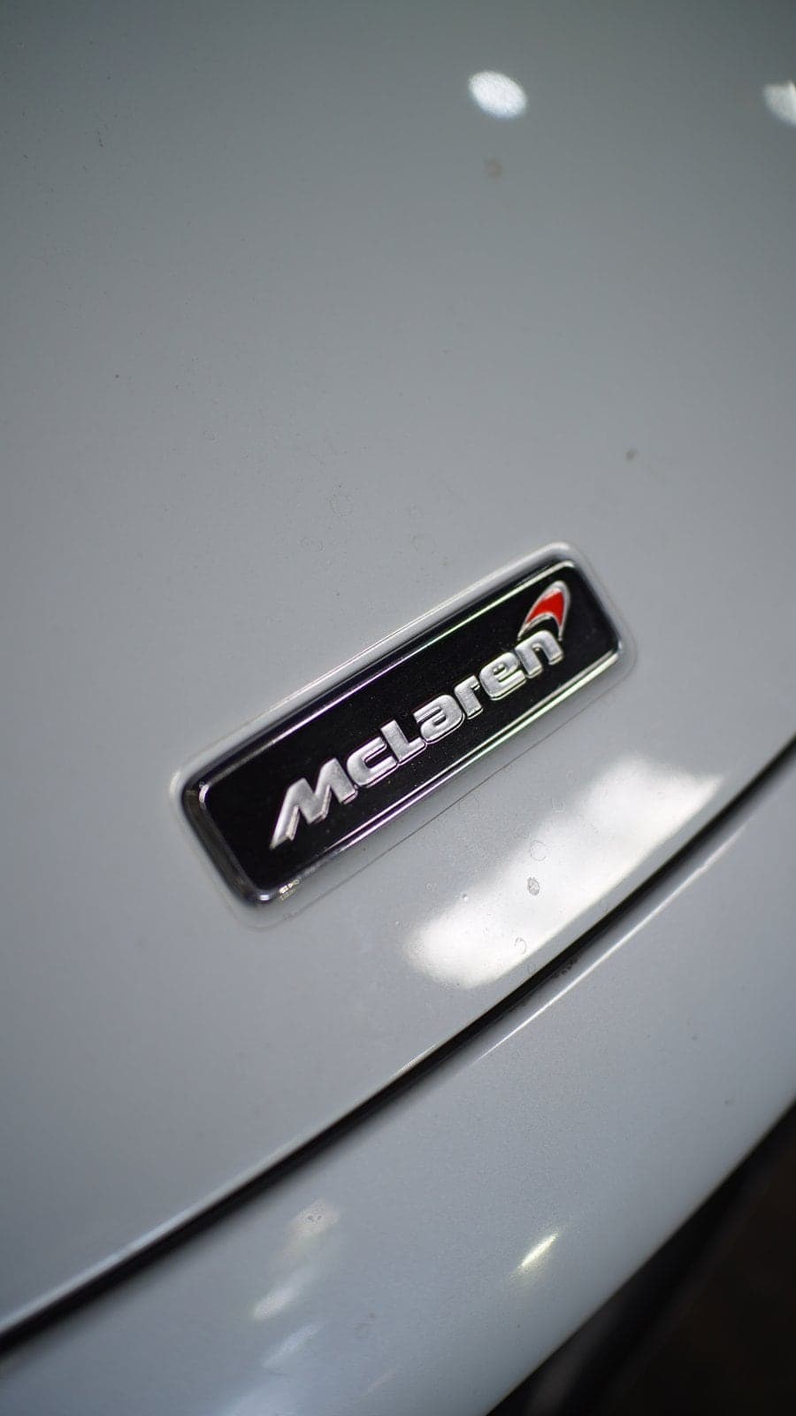 McLaren badge on the white bonnet of a McLaren 720S