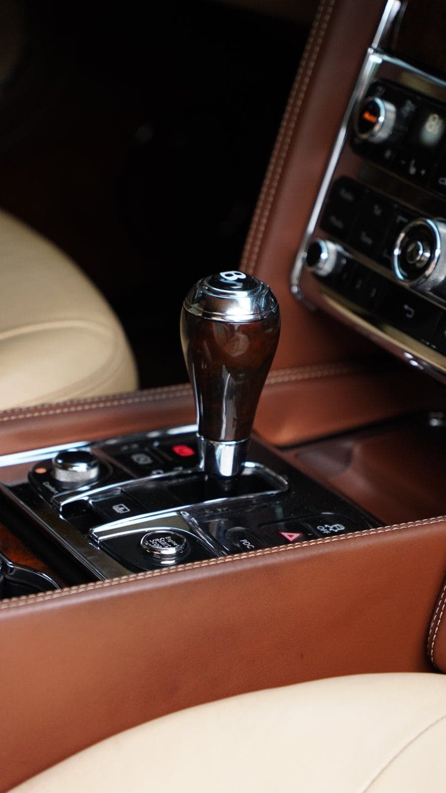 Wood and chrome gear selector in the tan leather console of a Bentley Mulsanne