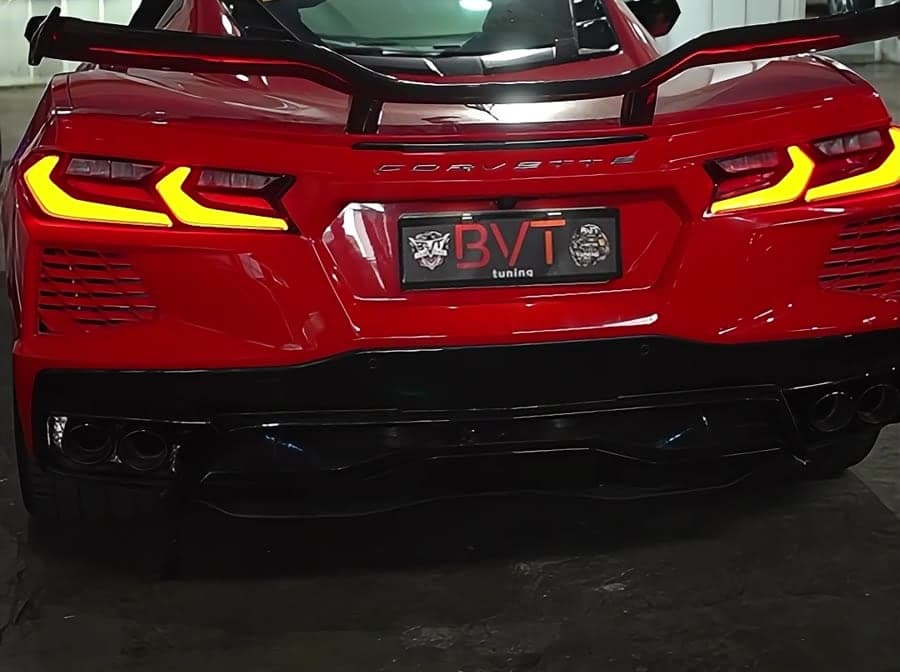 Rear of a red Chevrolet Corvette C8 with carbon rear wing and quad exhaust tips