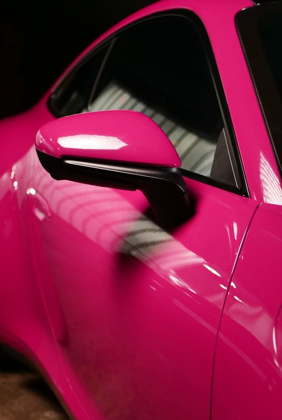 Glossy magenta colour wrap on a Porsche 911 door and side mirror