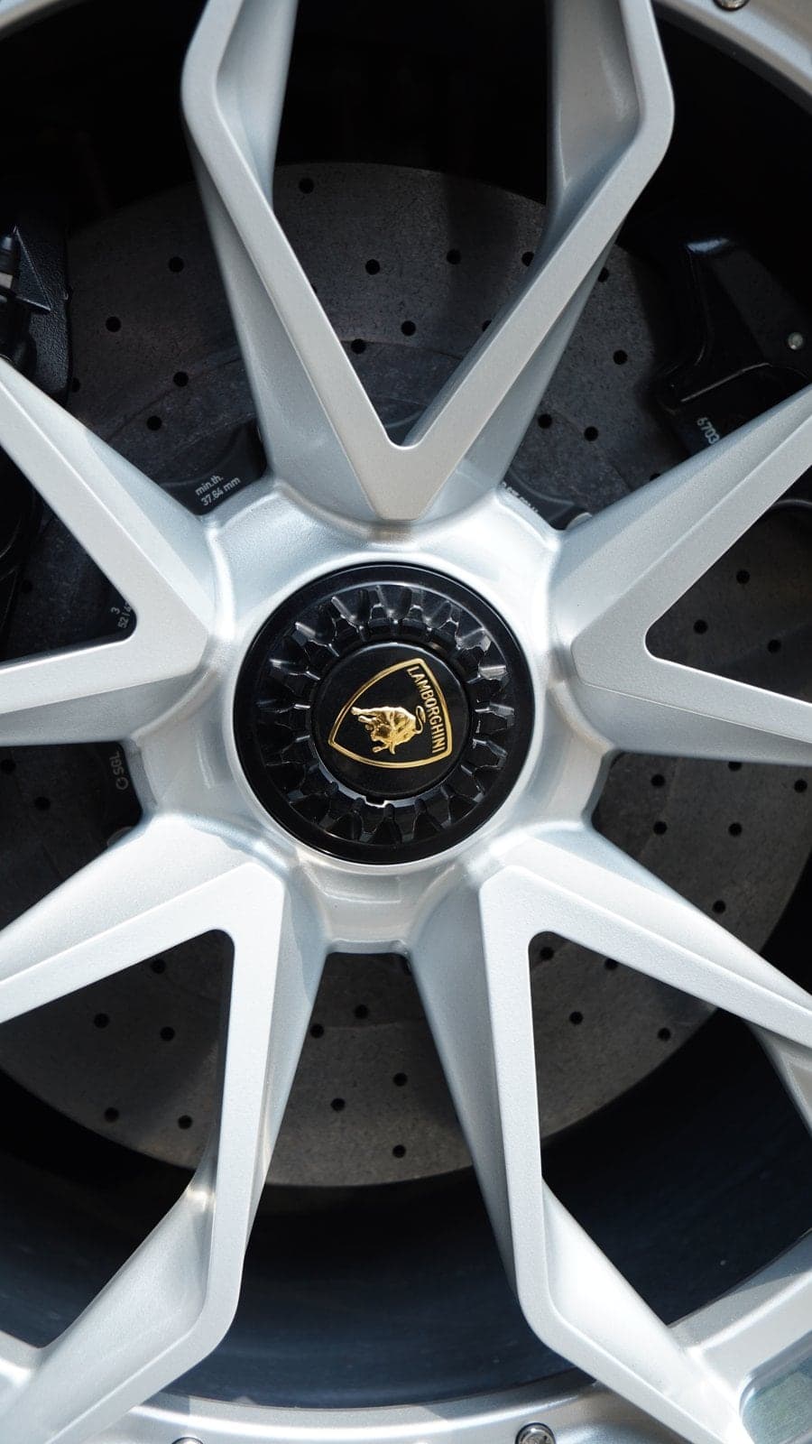 Lamborghini Aventador SVJ centre-lock wheel and carbon-ceramic brake disc in sunlight