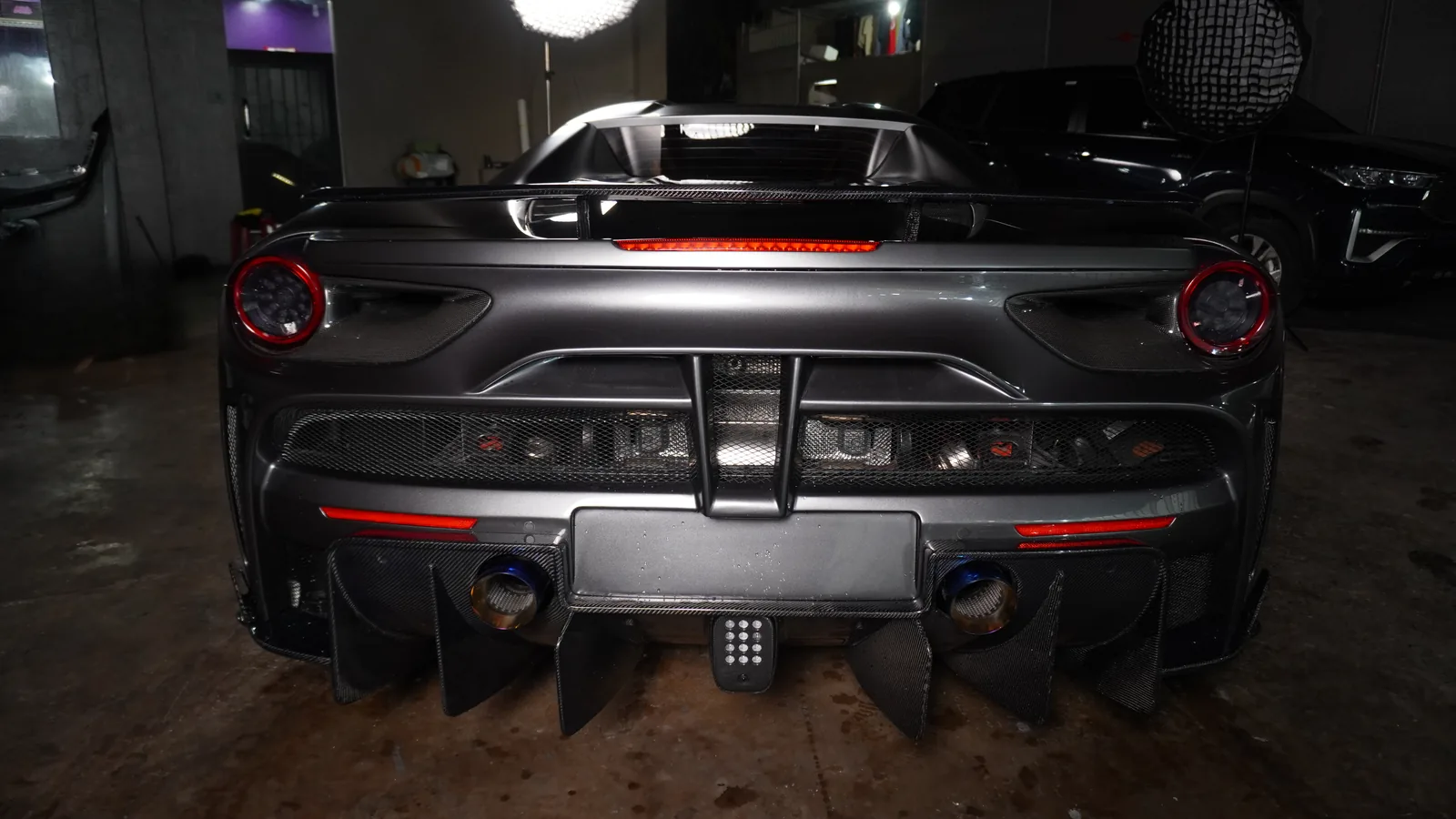 Rear of the Ferrari 488 Spyder with its carbon diffuser fins, centre light and blue exhaust tips