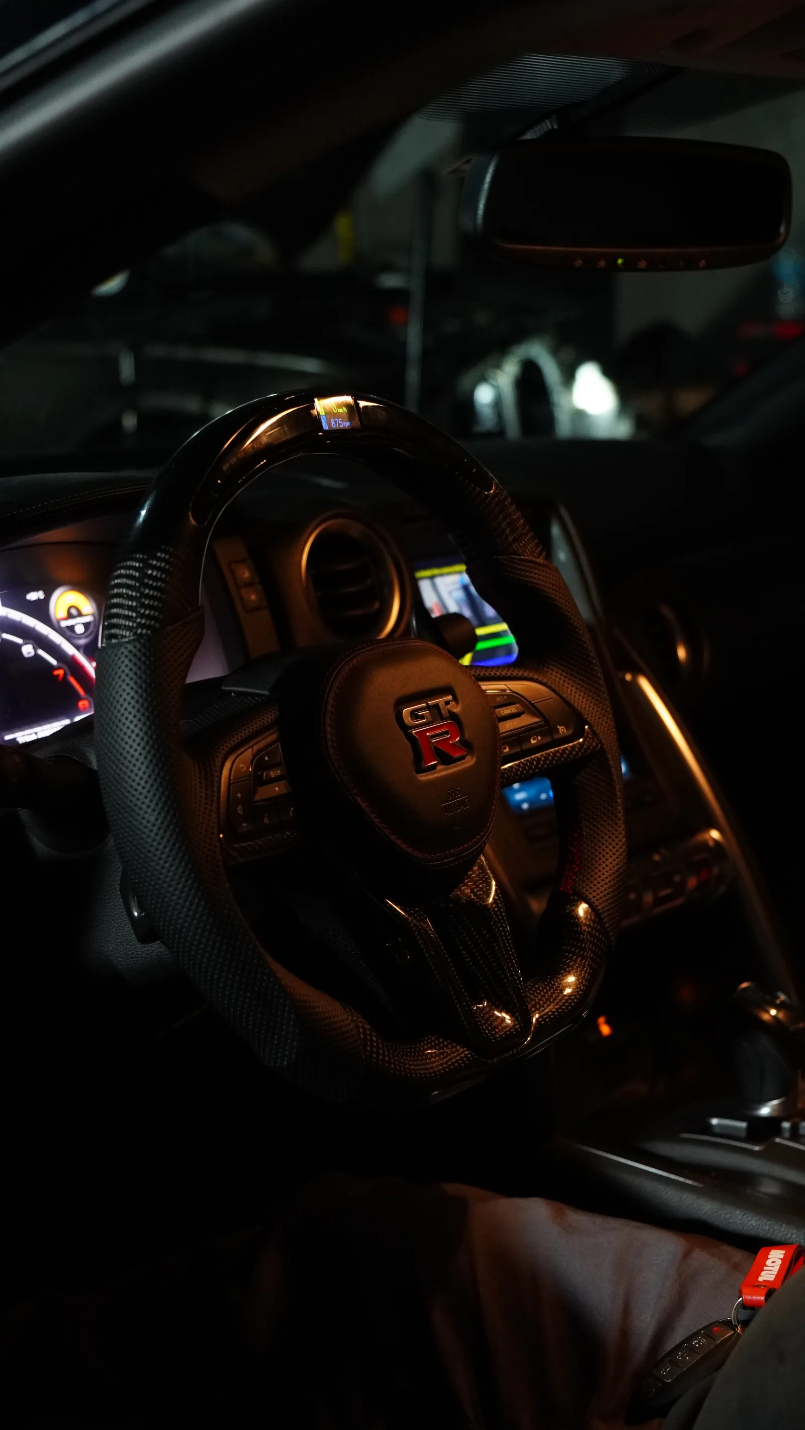 Carbon fibre and perforated leather steering wheel with LED display fitted in a Nissan GT-R R35