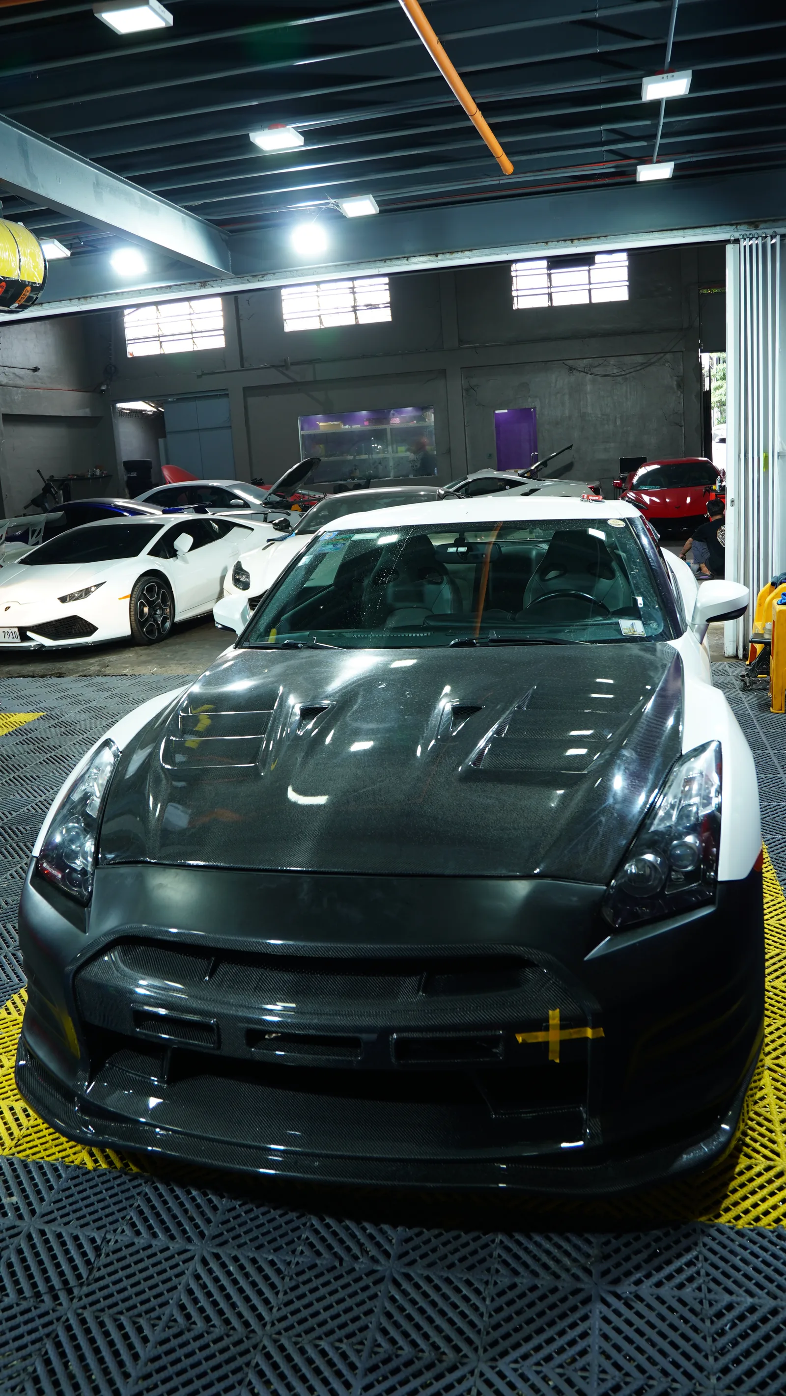 White Nissan GT-R R35 with the black Top Secret front bumper and carbon bonnet in the BVT bay