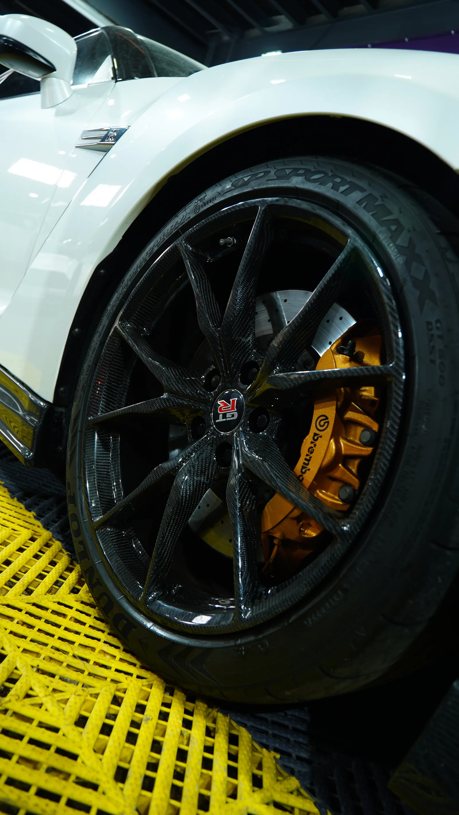 Nissan GT-R R35 wheel and orange brake caliper under the white front wing