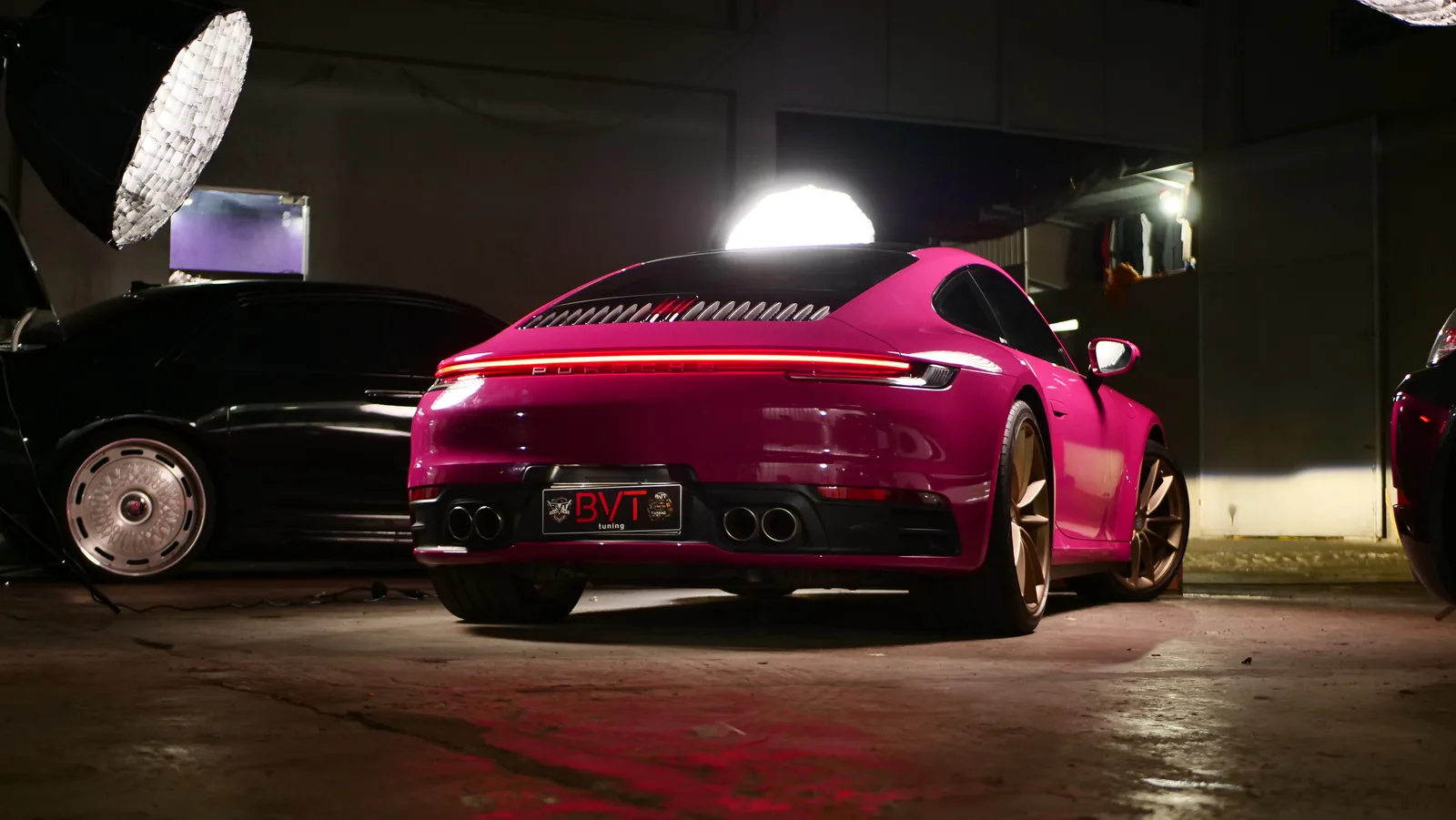 Rear three-quarter view of the Porsche 911 Carrera S in Shinobi Pink Gloss colour PPF with its light bar on