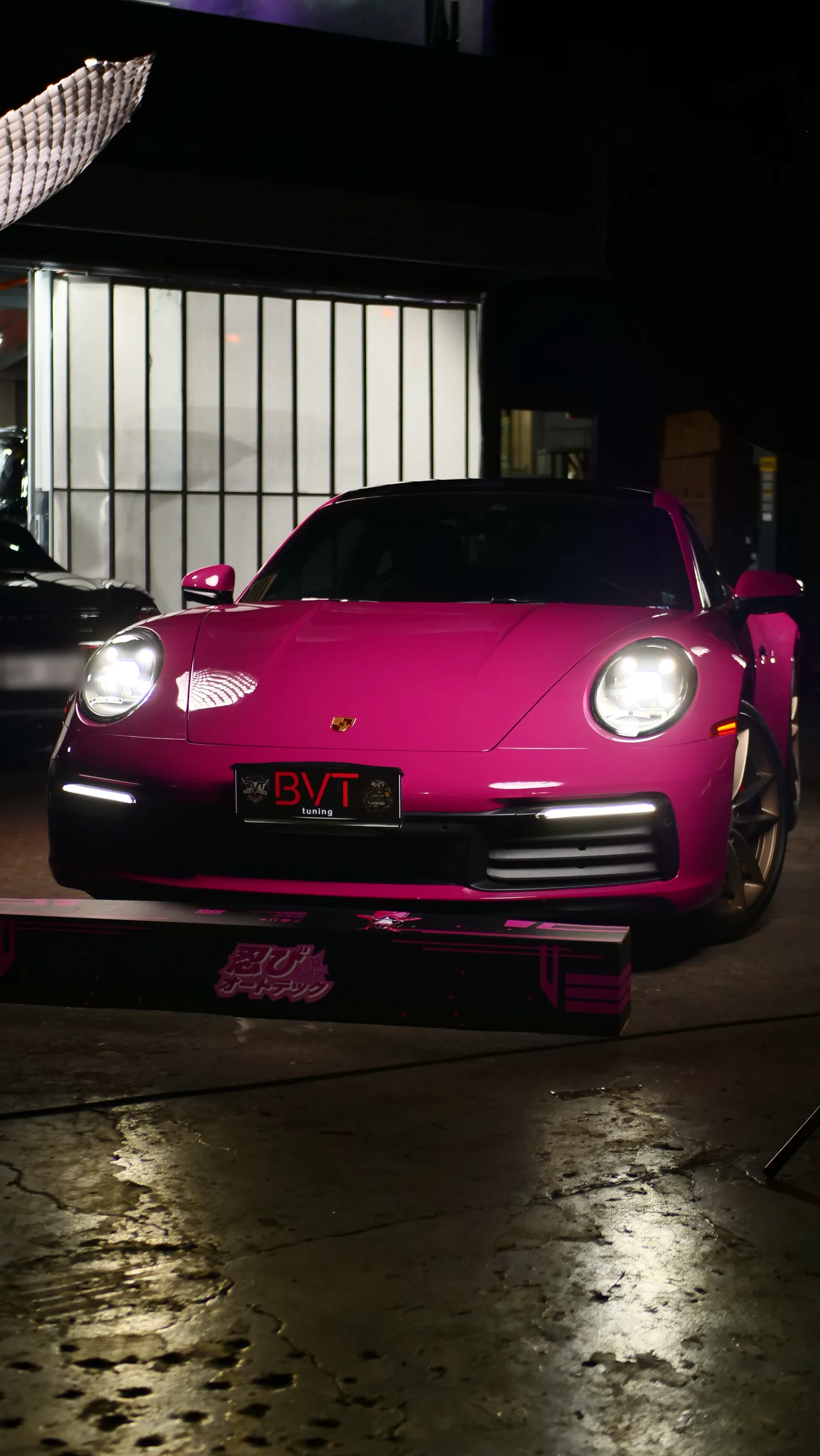 Front of the Porsche 911 Carrera S in Shinobi Pink Gloss colour PPF with headlights on