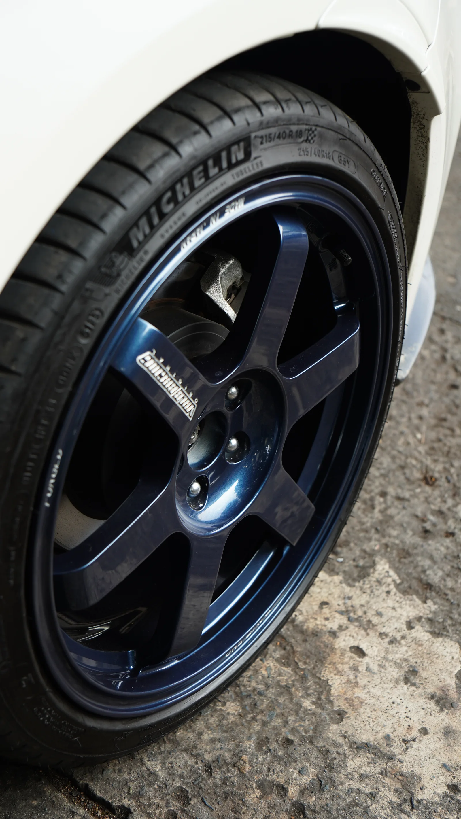 Close-up of the blue Volk Racing six-spoke wheel and tyre on the white Subaru BRZ