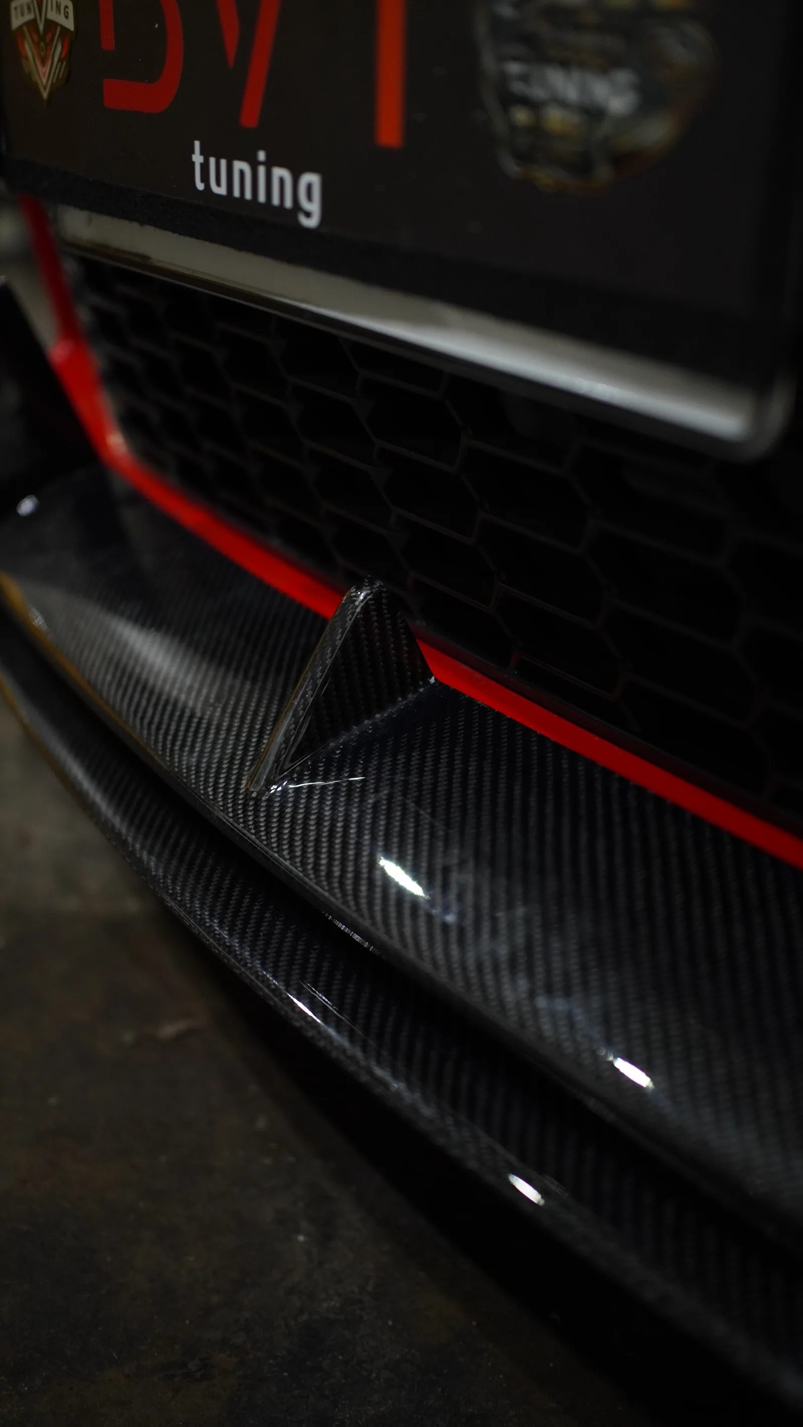 Gloss carbon fibre front lip and canard on a Toyota GR86 below a BVT Tuning plate