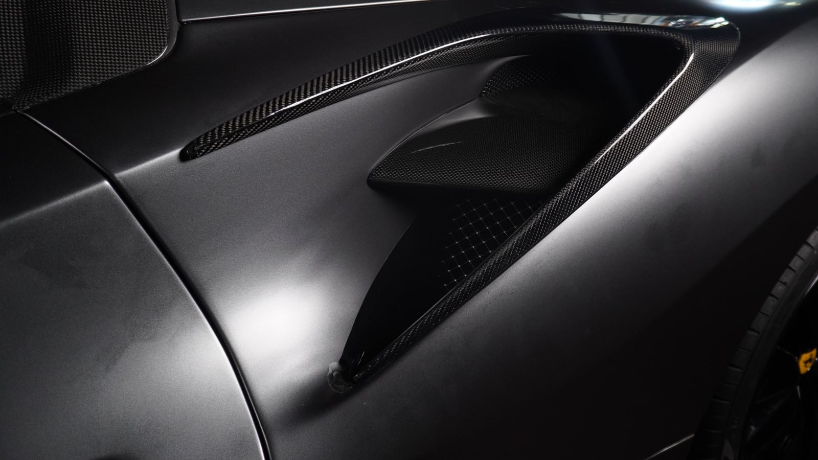 Carbon-trimmed side intake behind the door of a dark grey Ferrari 488 Spyder at BVT Tuning