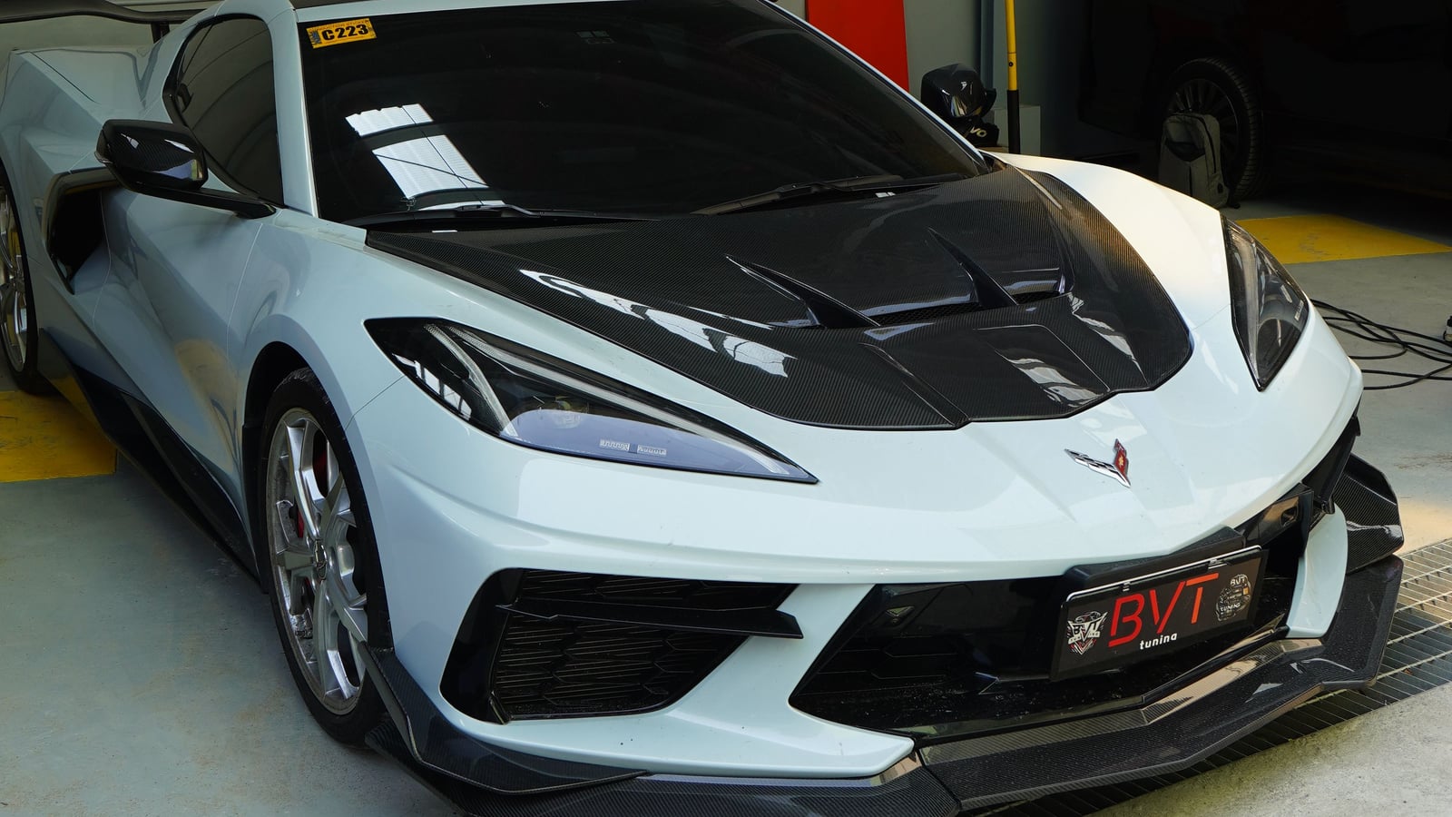 White Chevrolet Corvette C8 with a carbon bonnet and carbon front splitter at BVT Tuning