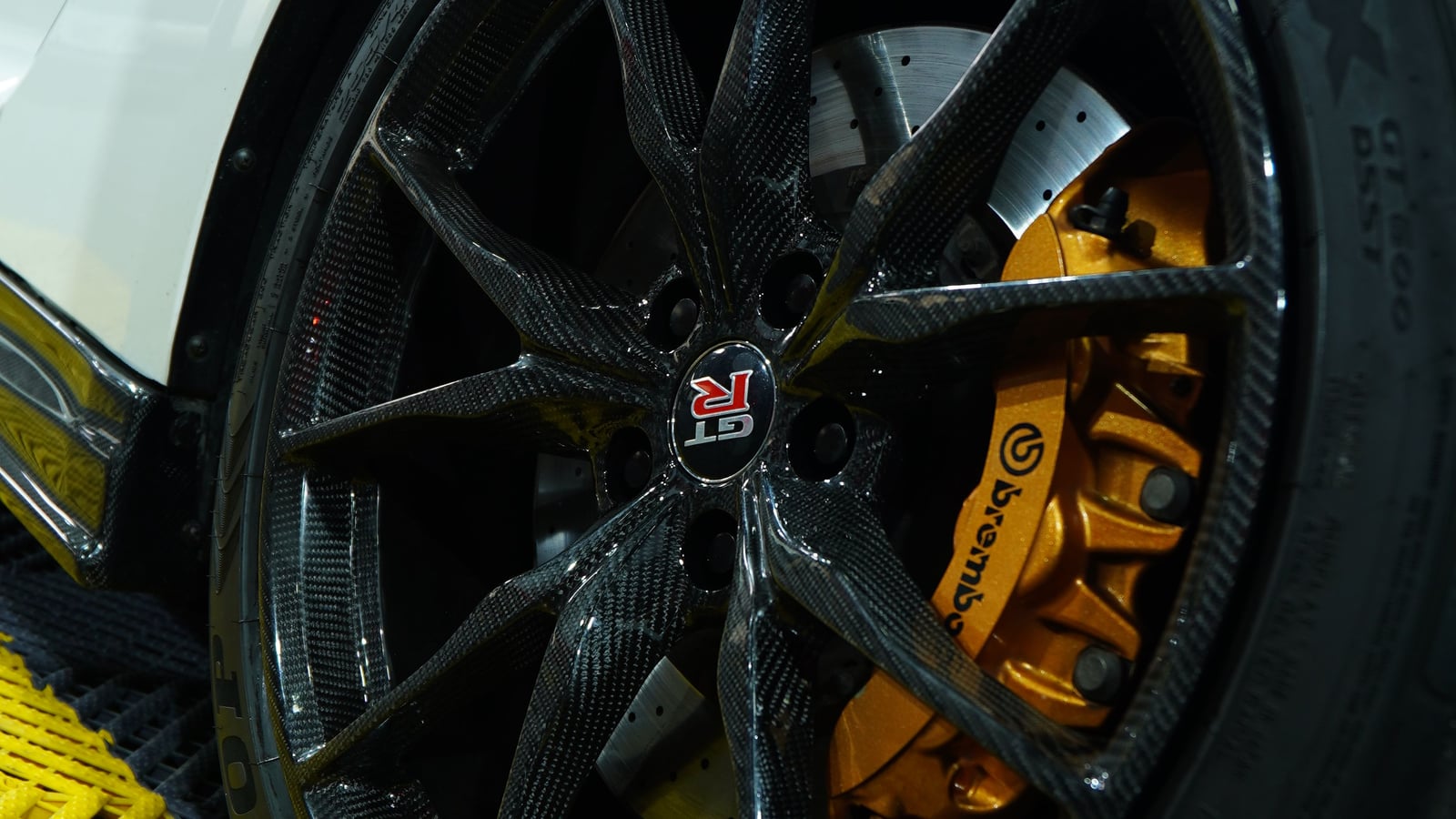 Carbon wheel and orange Brembo brake caliper on a white Nissan GT-R R35 at BVT Tuning