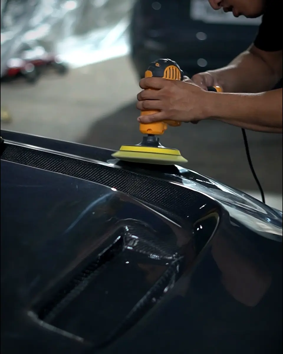 Machine polisher working on black paint