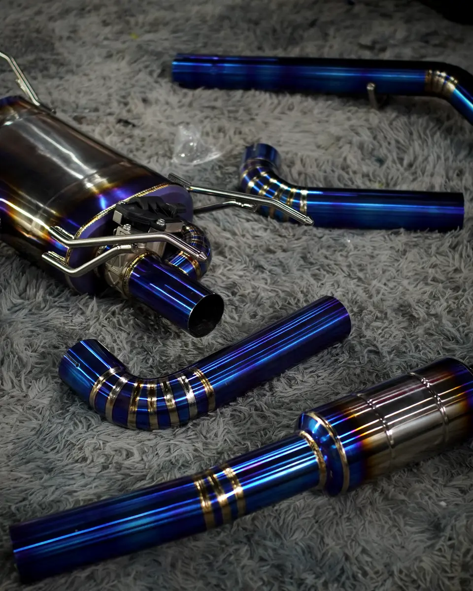 Titanium exhaust system with burnt-blue pipes laid out before fitting