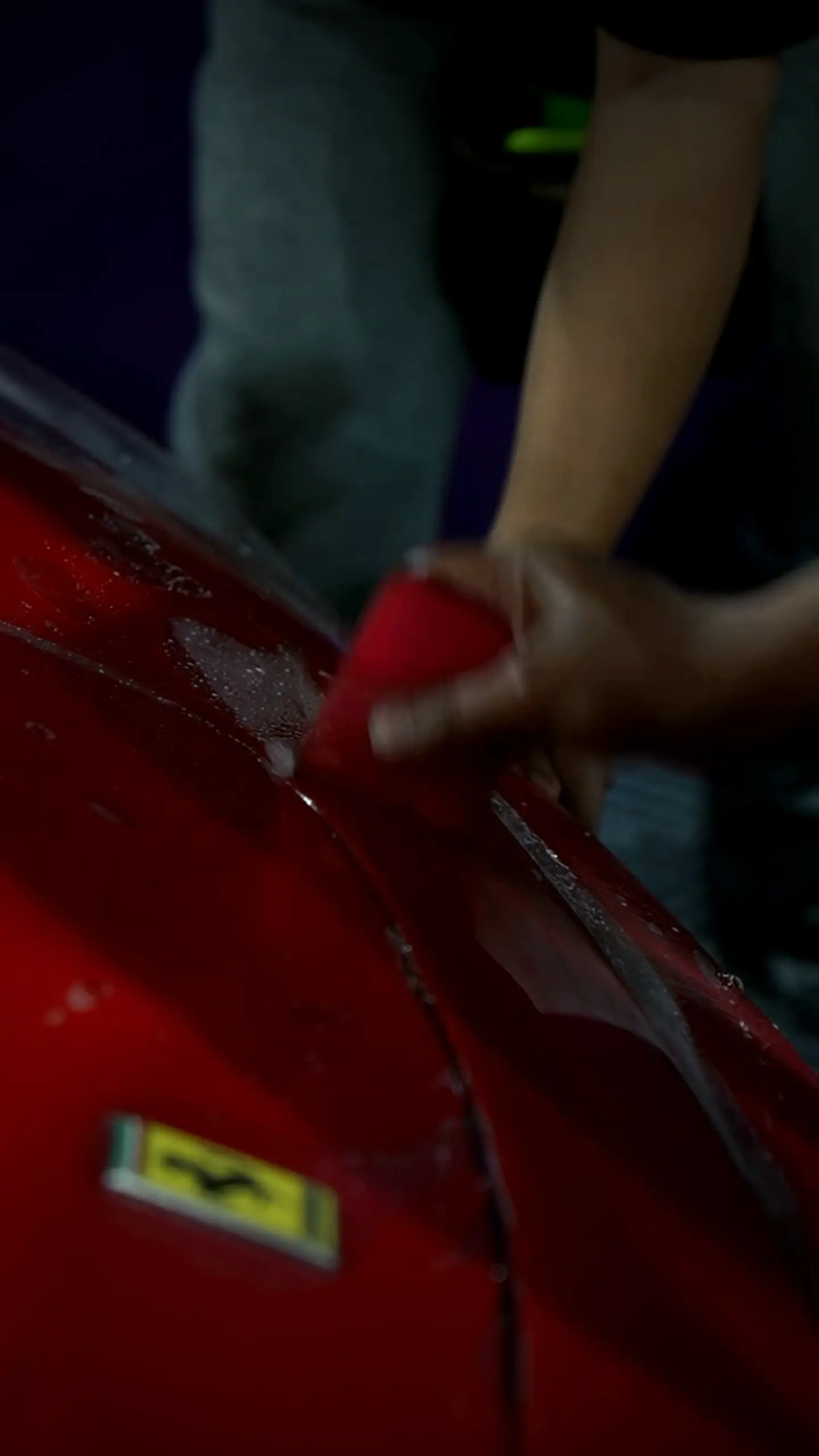 Clear PPF being laid on the hood of a red Ferrari F430